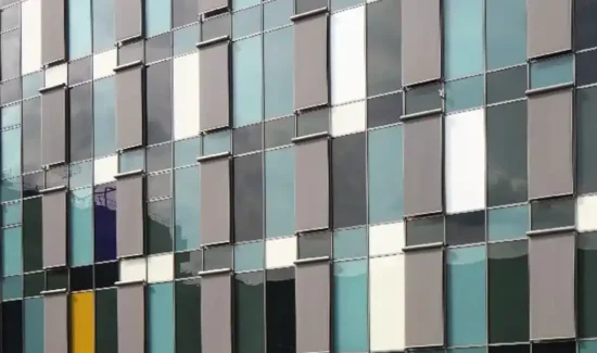 Moderne Fassade mit farbigen Flächen und vielen Fenstern.