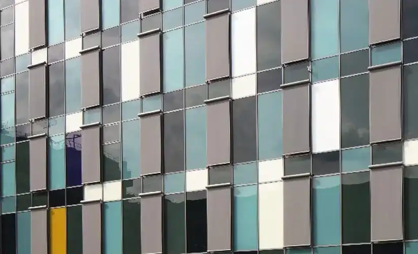 Moderne Fassade mit farbigen Flächen und vielen Fenstern.